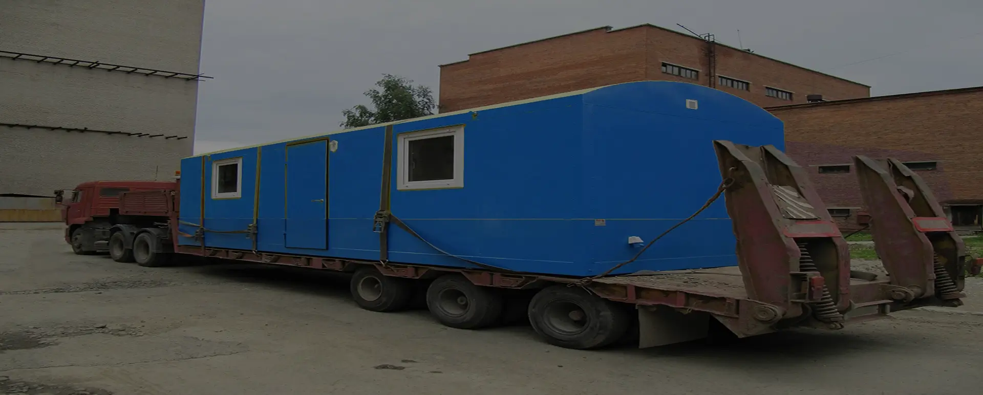 Заказать безопасную и качественную перевозку вагон домов и блок комнат по России из Красных Баррикад специализированными низкорамными тралами